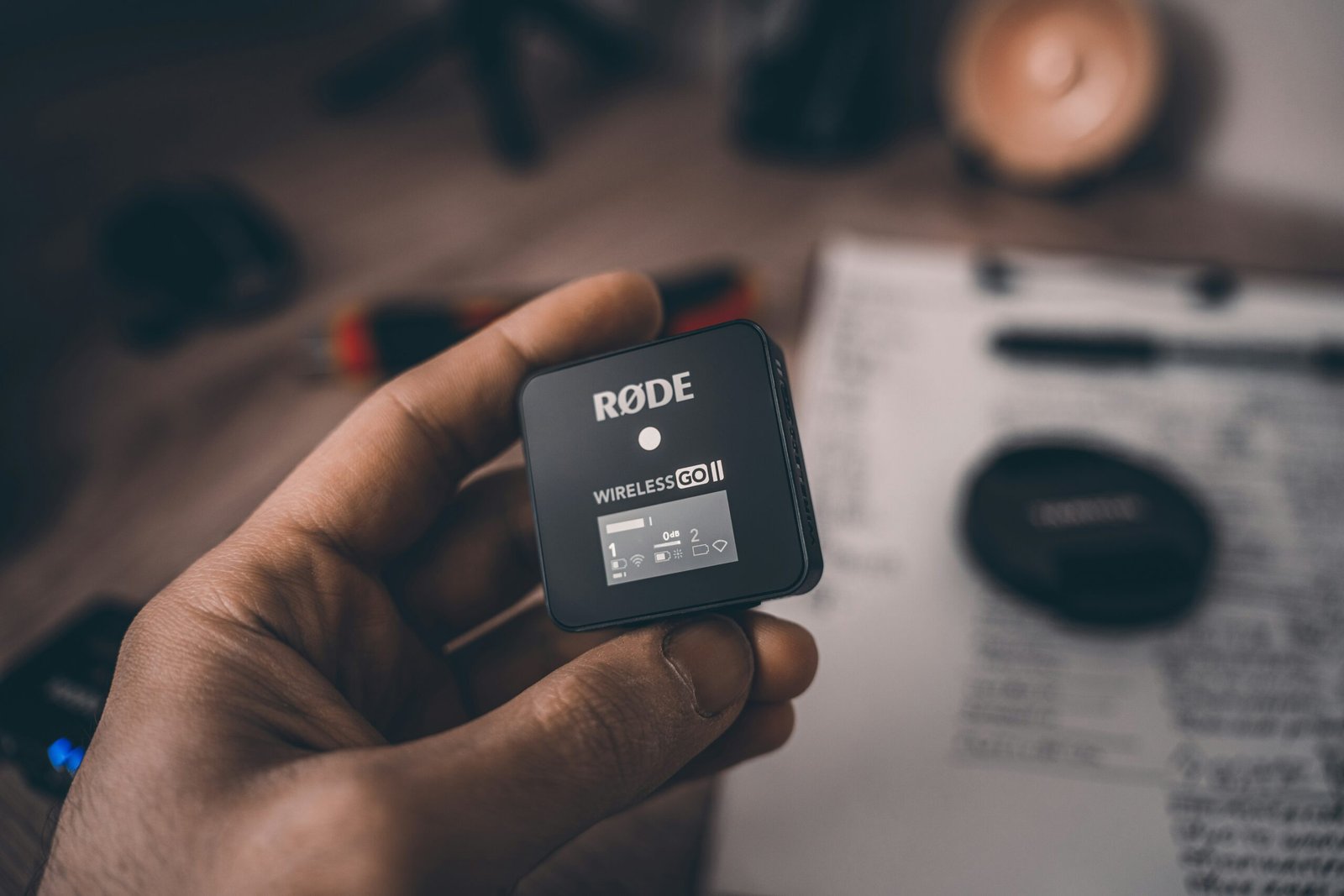 a hand holding a small black device